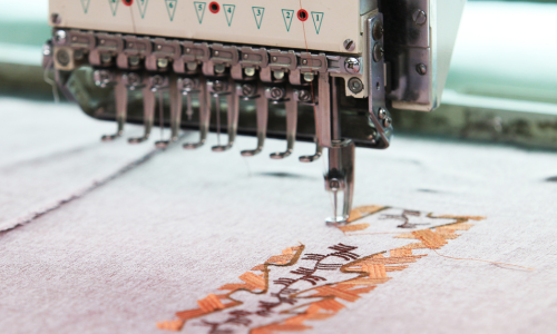 an embroidery machine is working on a piece of fabric
