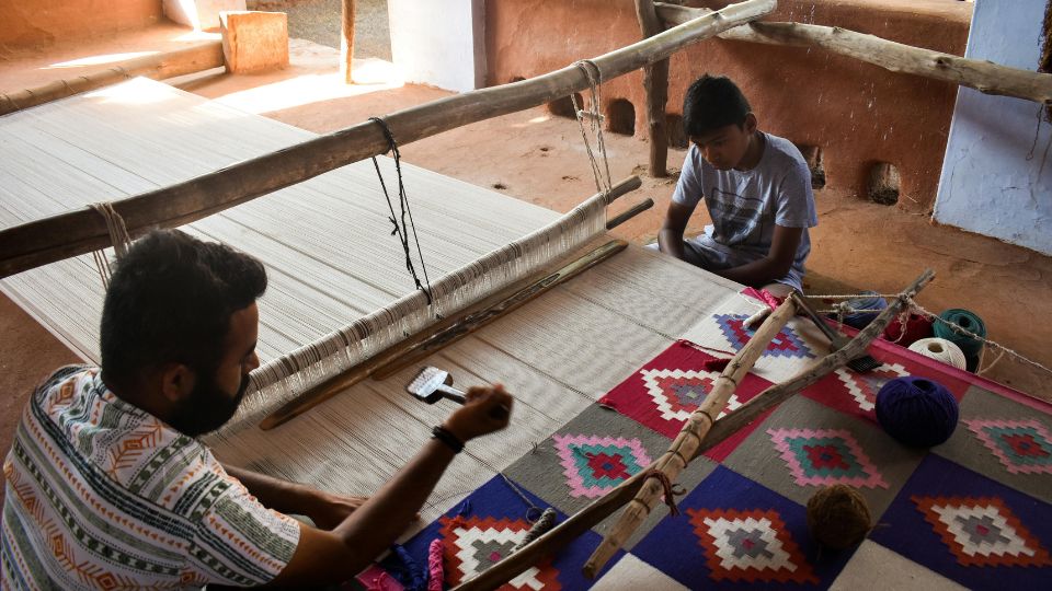 two artisians hadn weaving carpet