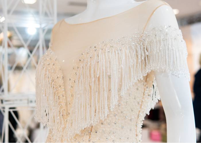 luxury couture fashion collection development process, closeup of fringe white dress in a mannequinn