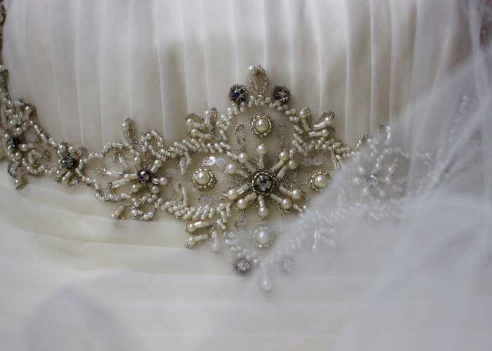 closeup of a beaded work in a white garment